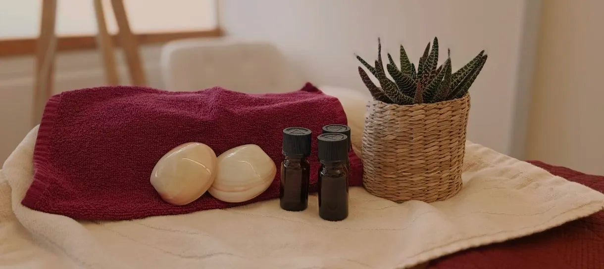 Warme Aromatherapie-Szene mit ätherischen Ölen, Handtüchern und Pflanzen in der Massagepraxis Olvenia