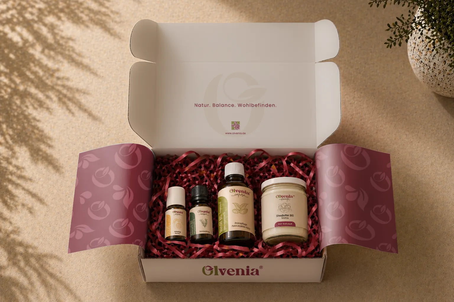 Olvenia alle Produkte in geöffneter Geschenkbox mit burgunderfarbenem Füllmaterial