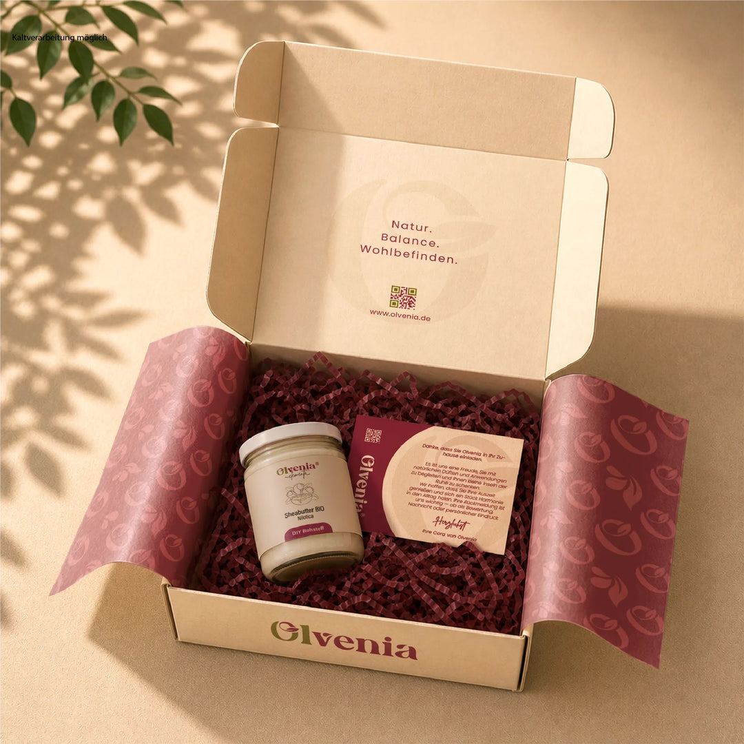 Olvenia Elementa Sheabutter Bio Nilotica in geöffneter Geschenkbox mit Seidenpapier, Füllmaterial und Dankeskarte